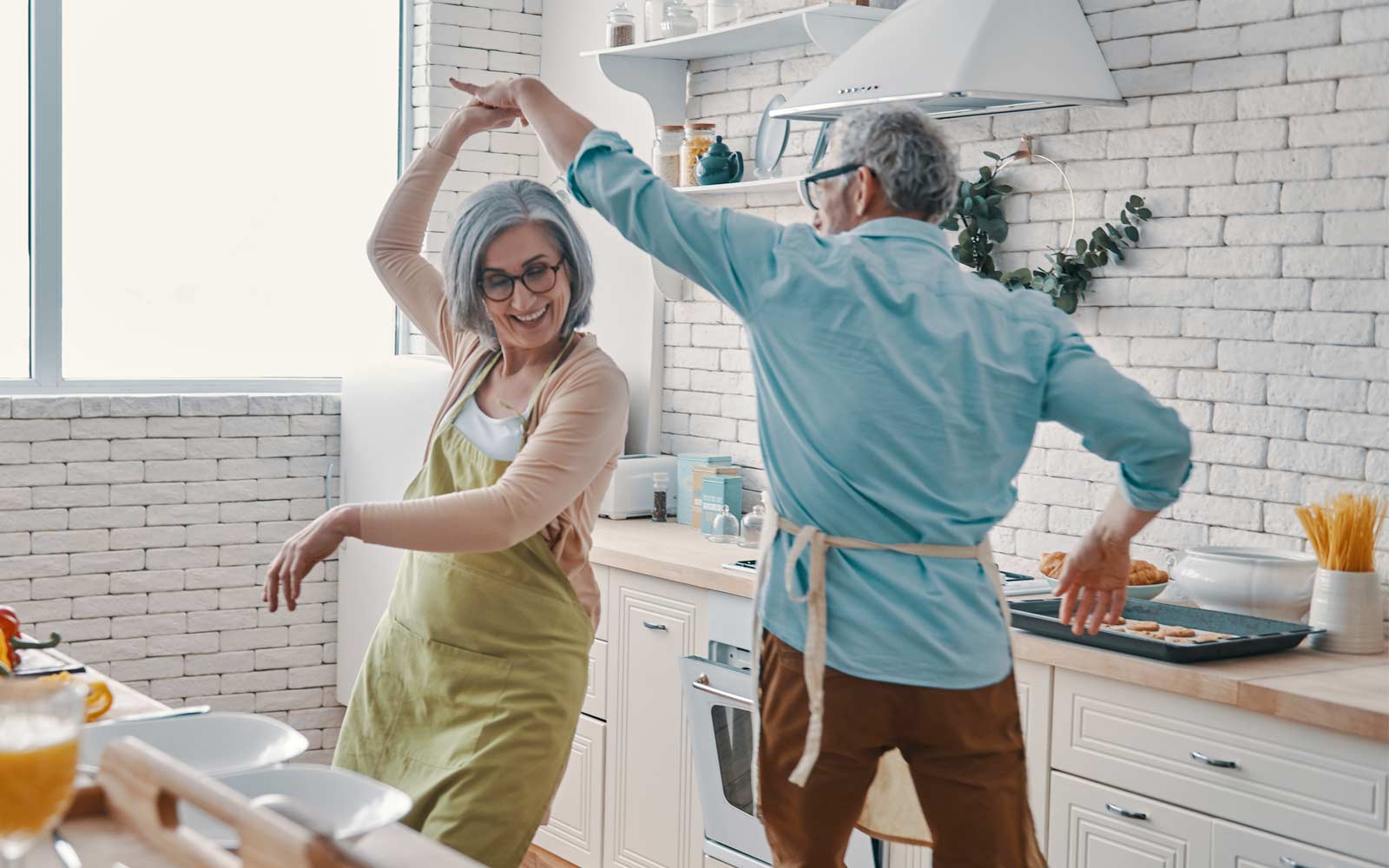 A happy couple dance in their kitchen