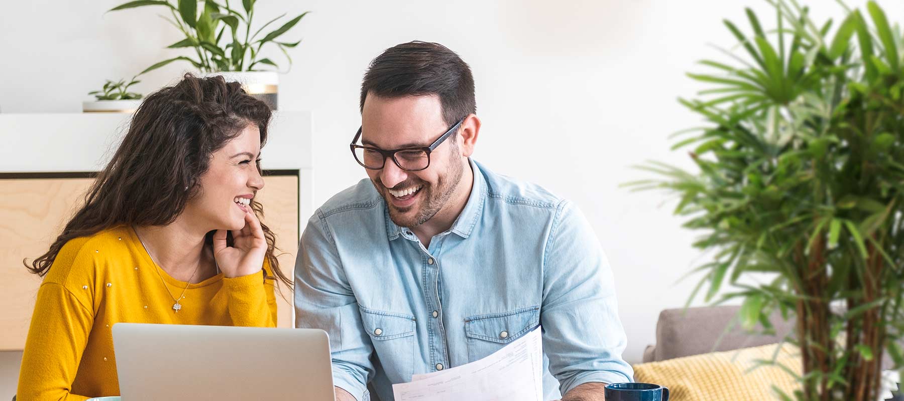 A young couple is happy when reviewing papers and a computer