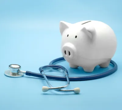 A piggy bank wrapped up by a stethoscope