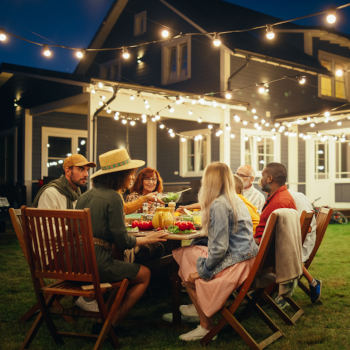 A family enjoying dinner outside their house